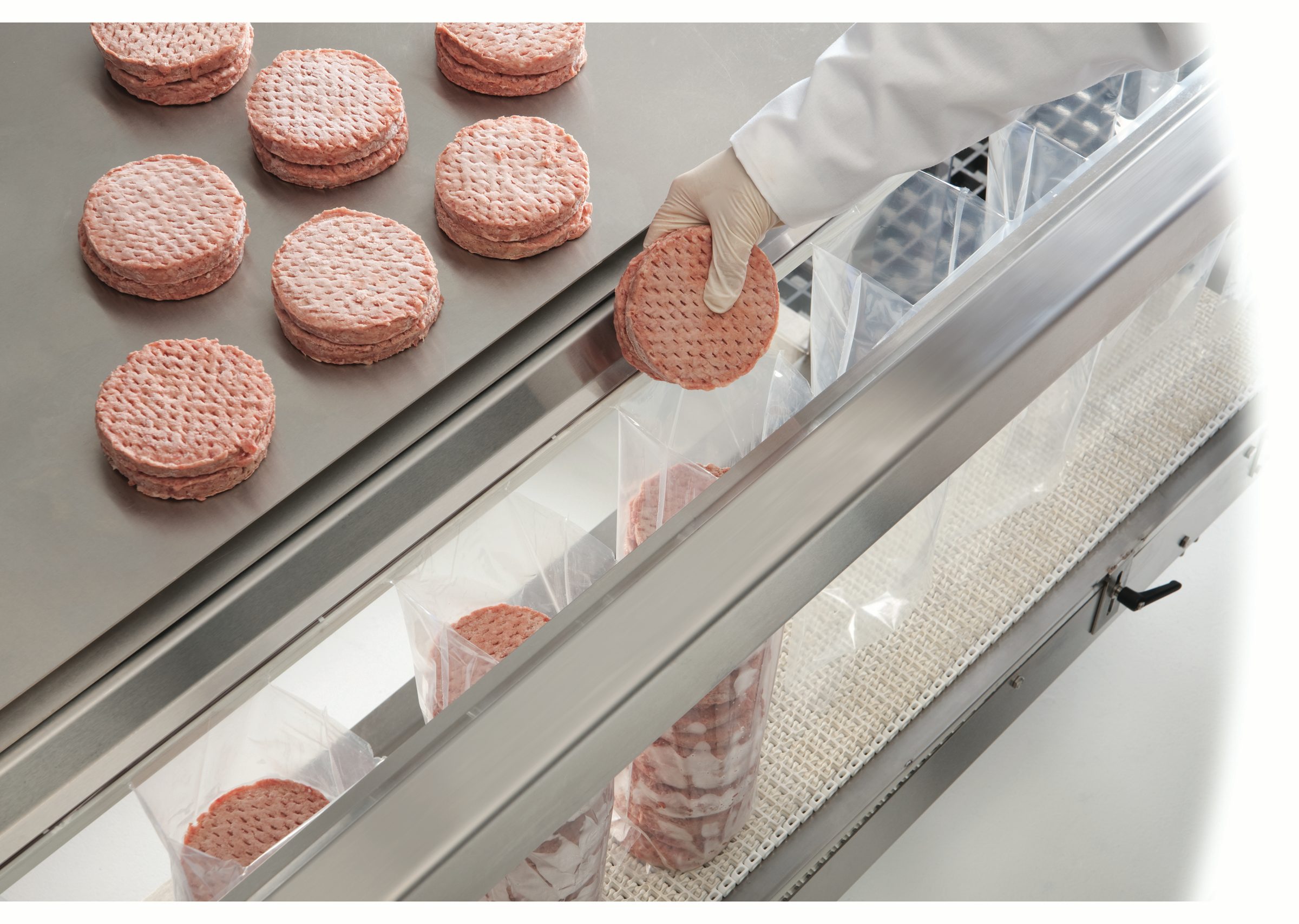 worker placing burger patties into SidePouch System