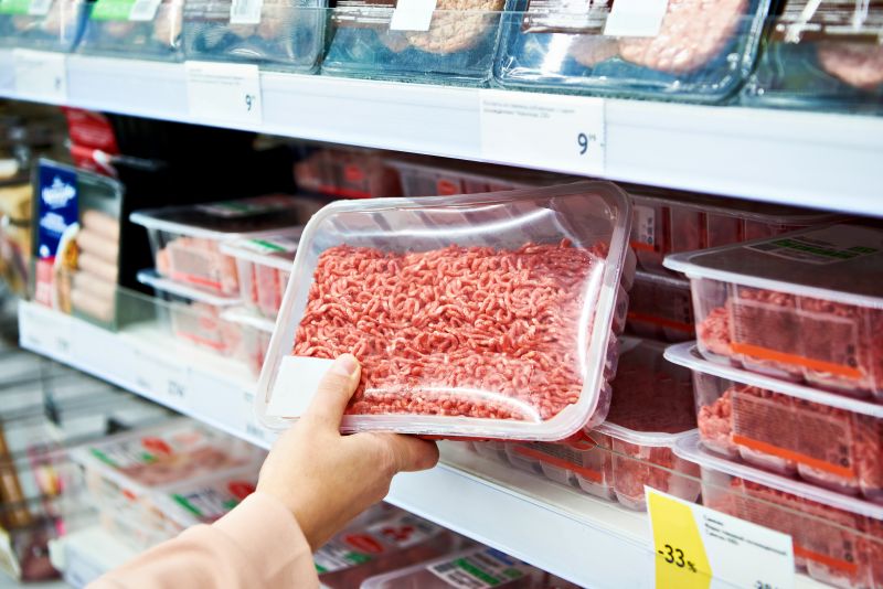 shopper looking at case-ready meat in supermarket