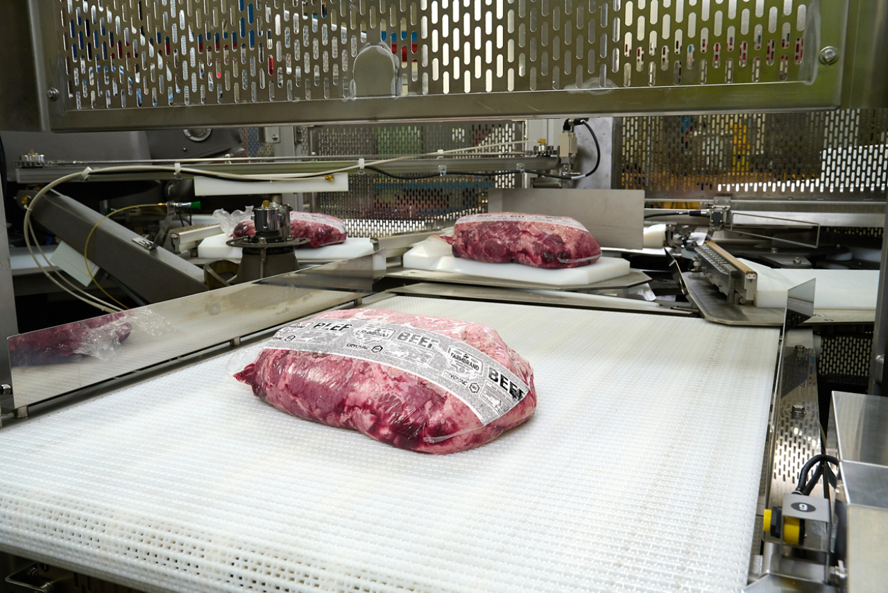 A stream of beef that has been packaged digitally is moving on a conveyor belt.