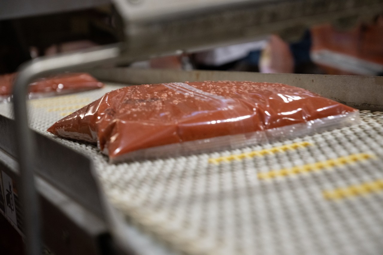 flexible pouches on conveyor with workers talking