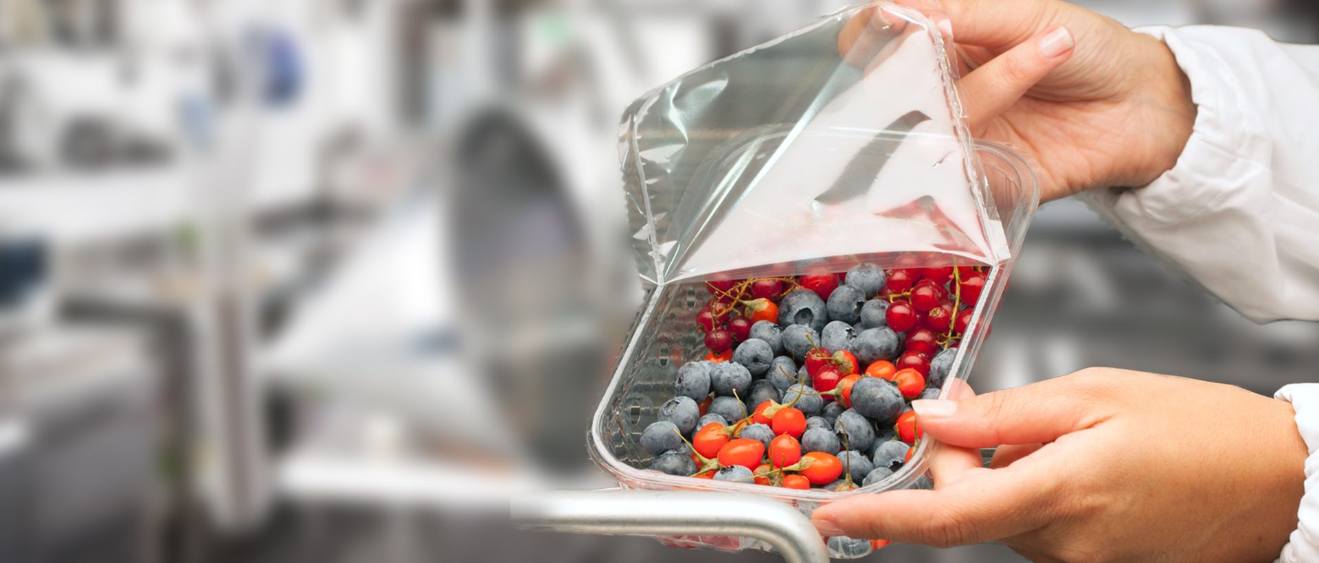 woman opening a lid film container filled with berries