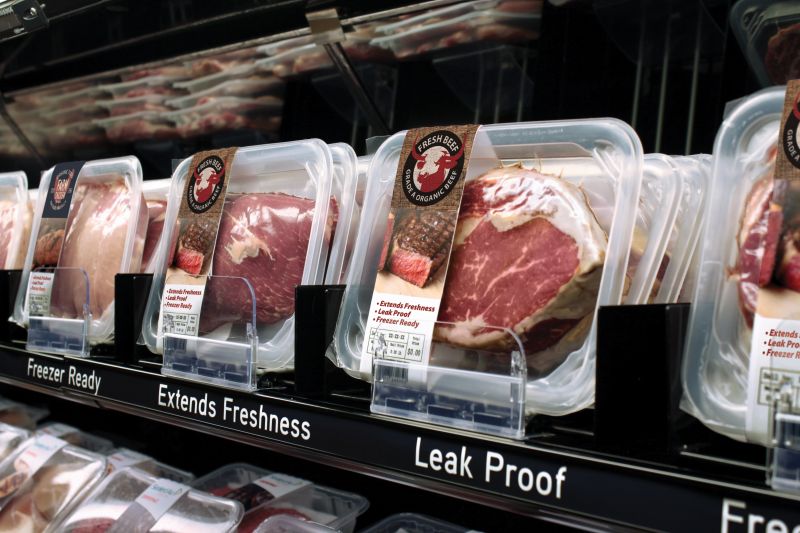 Grocery shelf with several Cryovac case ready meat packaging containers displayed