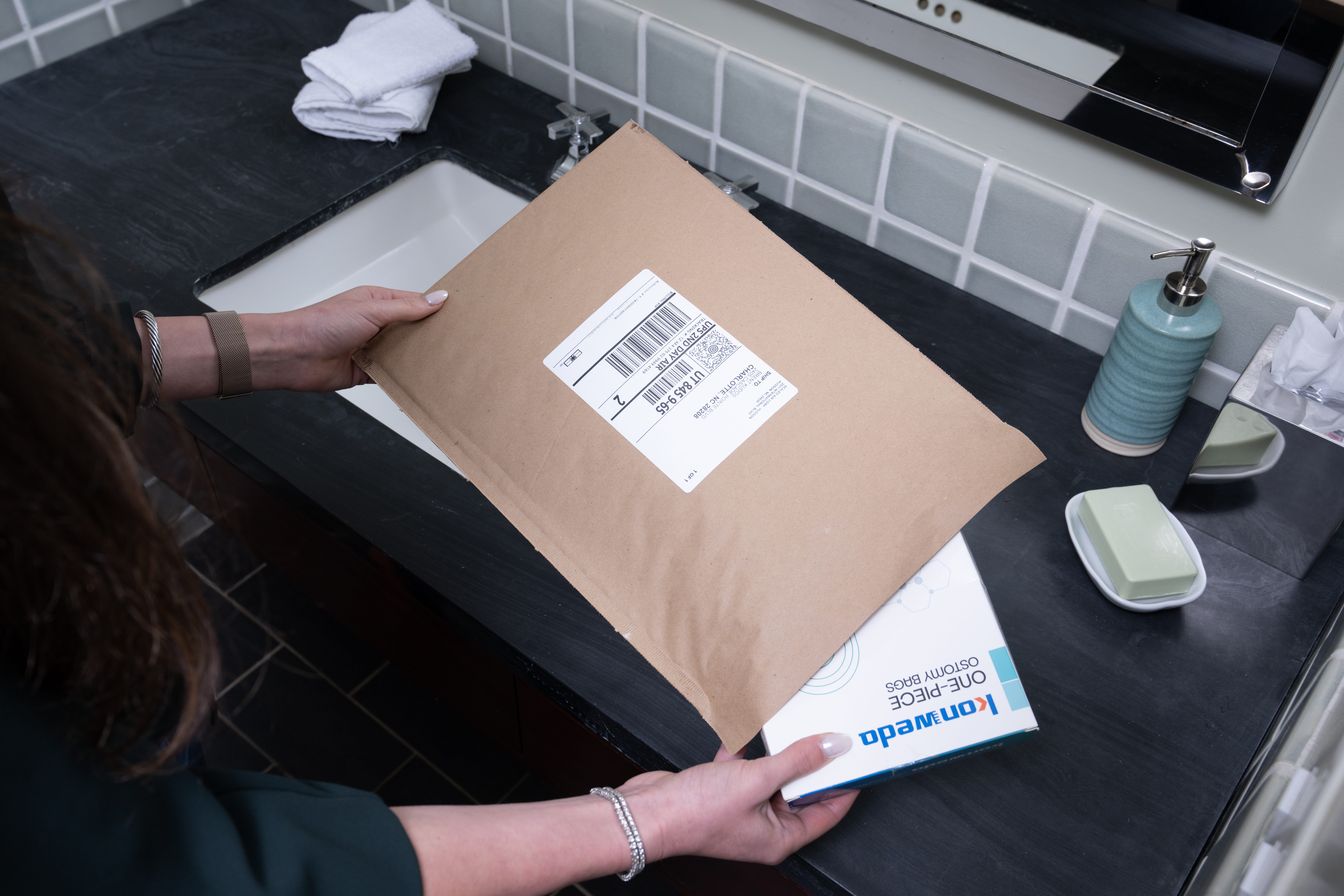 consumer opening ecommerce order in paper bubble mailer 