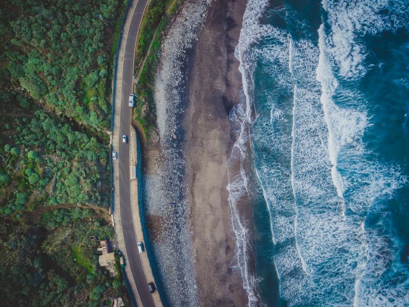 auto che viaggiano sulla strada vicino all’oceano