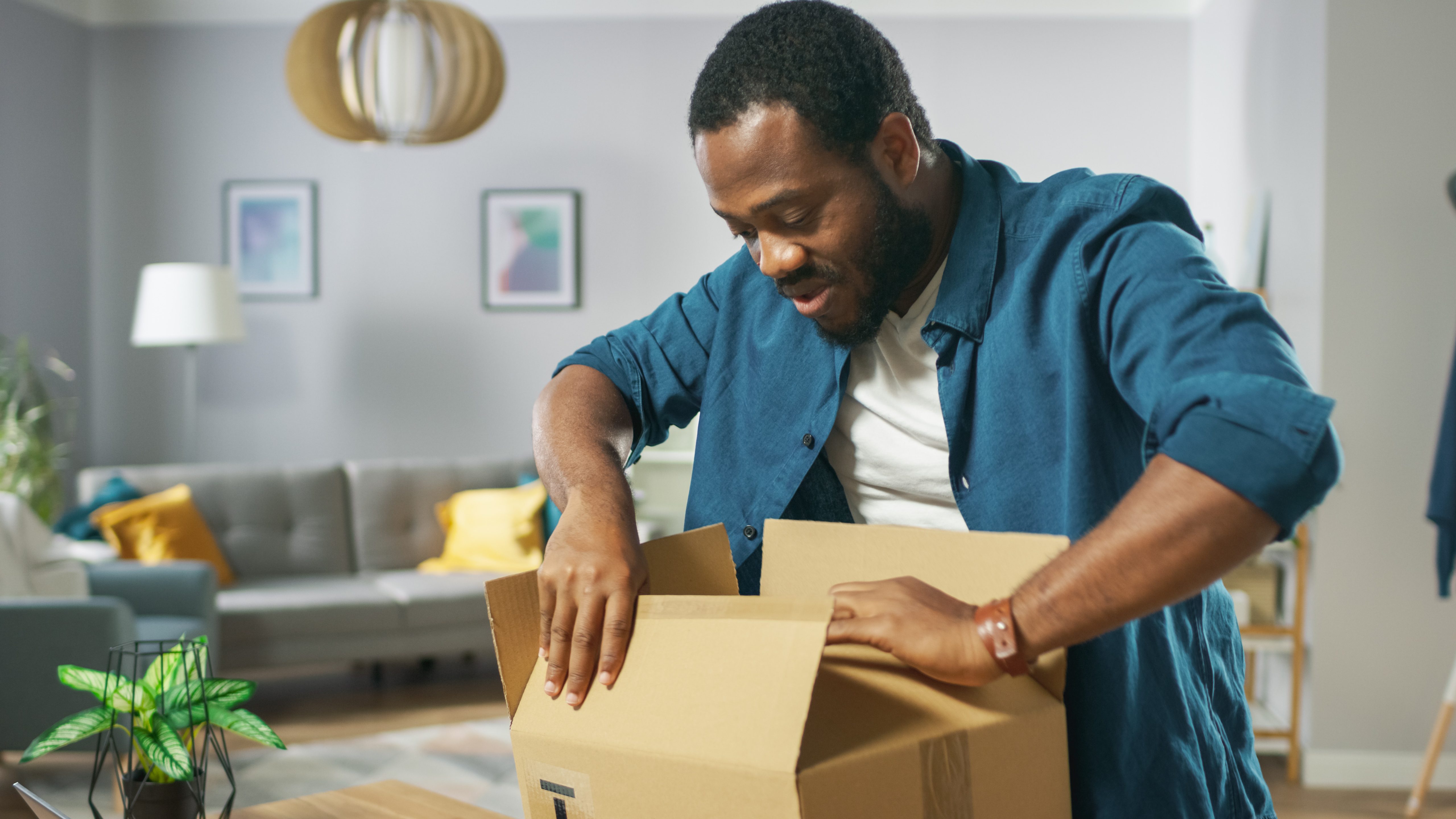 Hombre cerrando caja y preparándola para enviarla