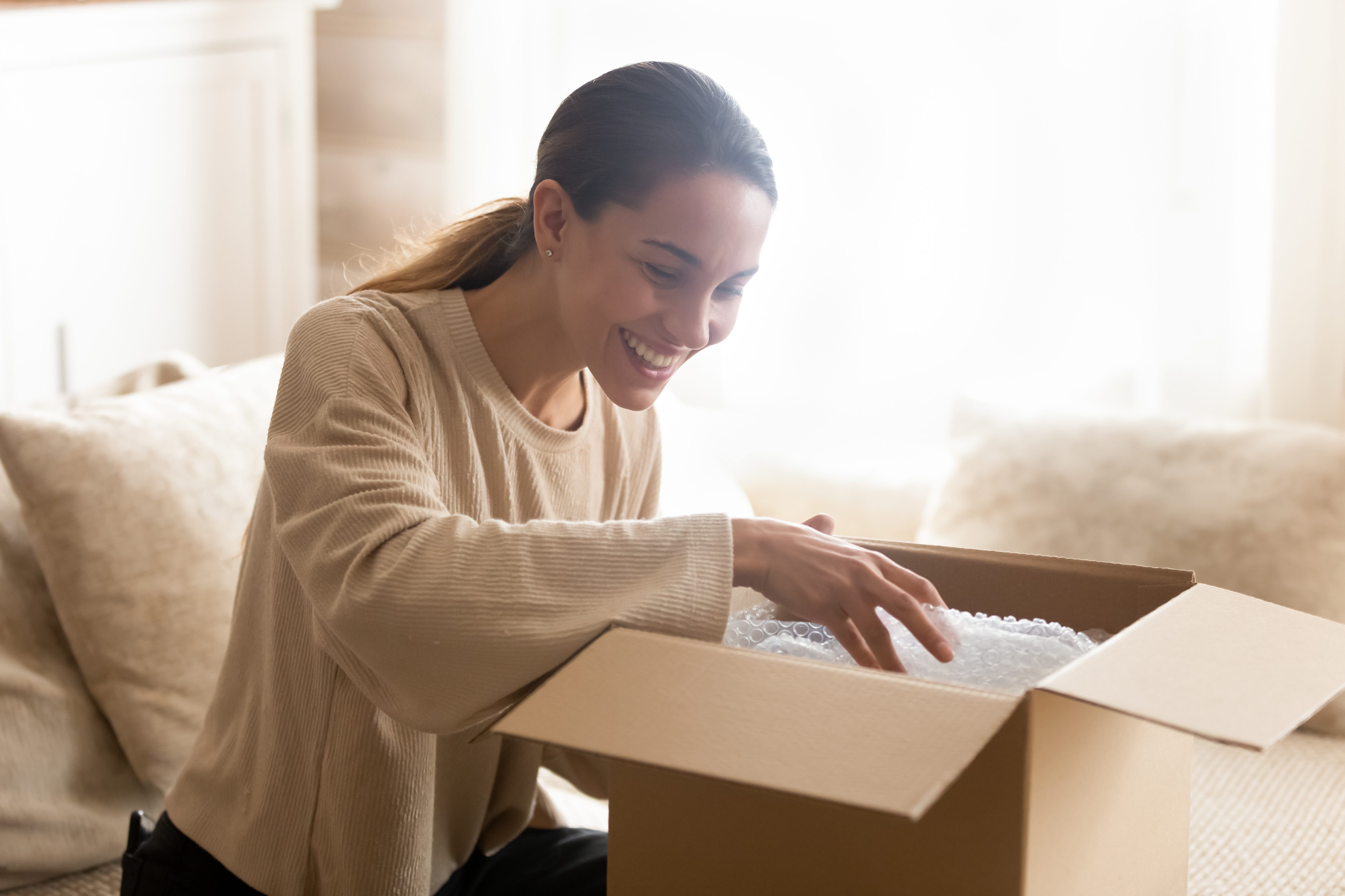 woman opening package with bubble wrap