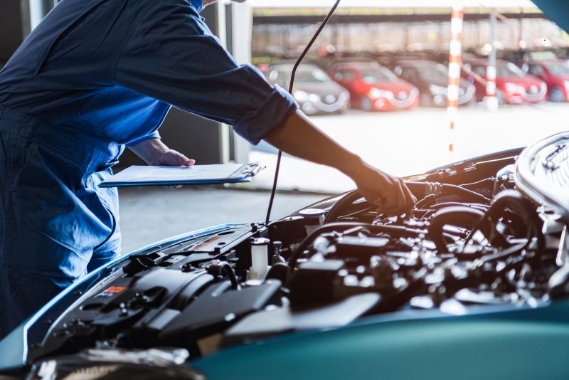 mechanic looking at auto parts in car engine