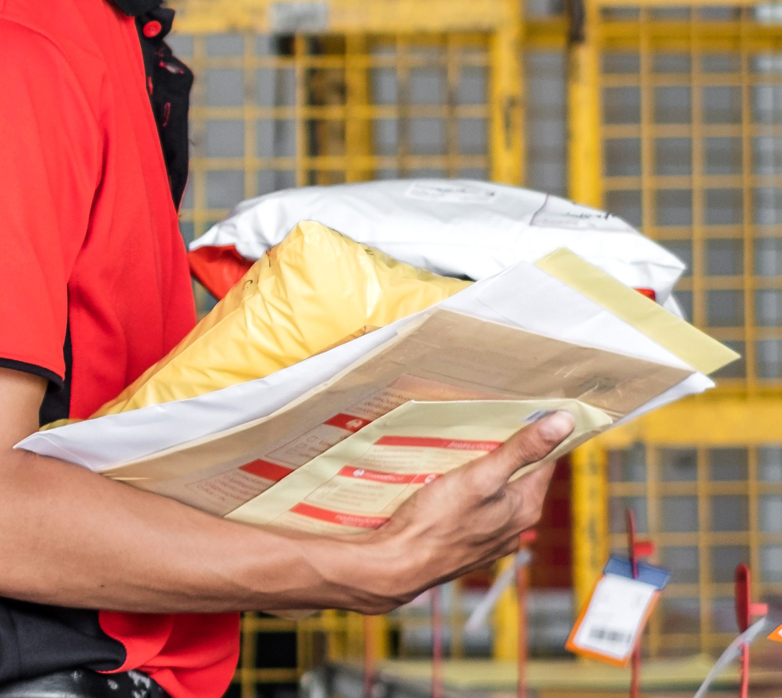 Empleado abrumado con los brazos llenos de paquetes devueltos