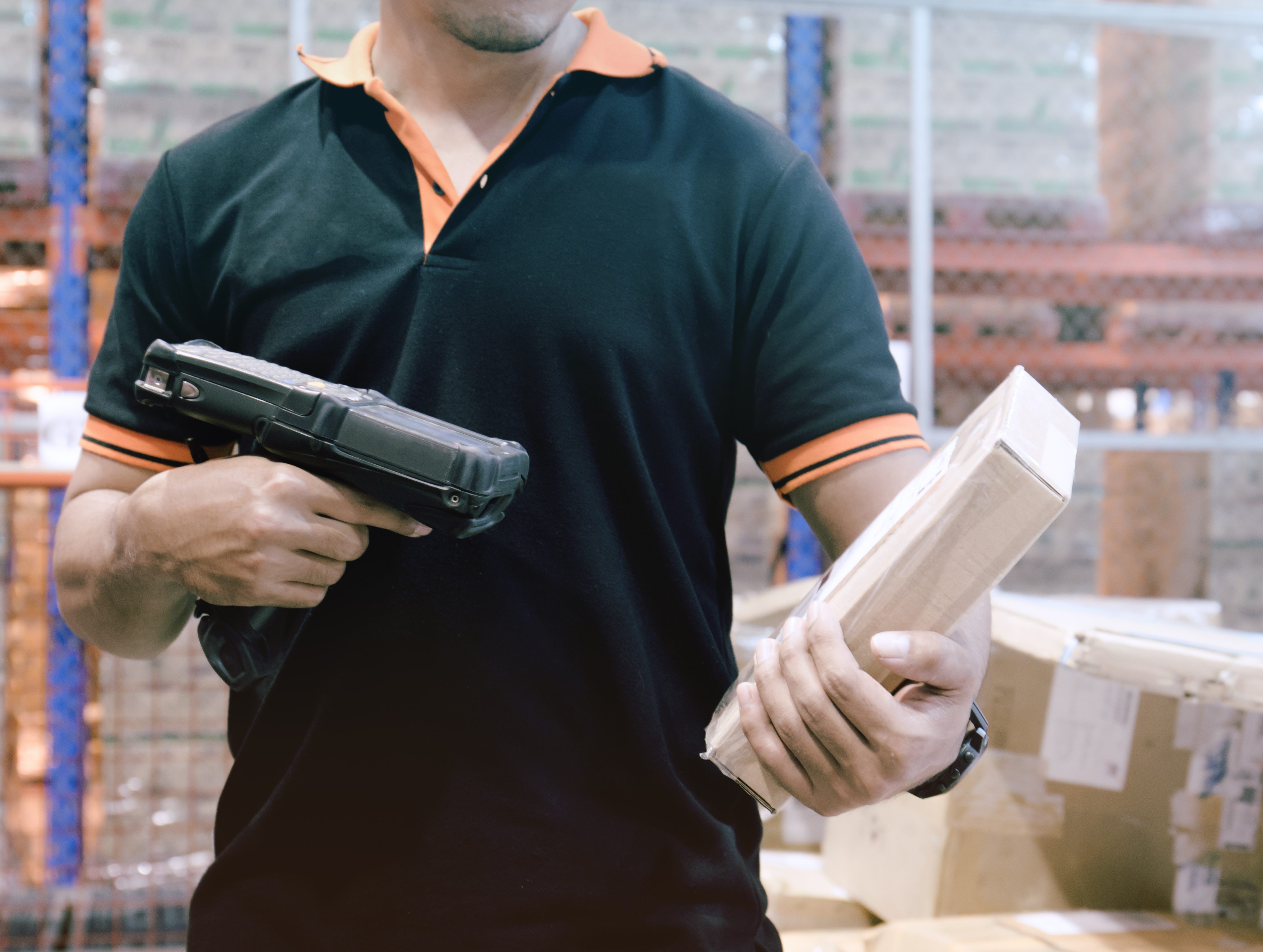 hombre escaneando un paquete que muestra el proceso de soluciones tecnológicas para el cumplimiento de pedidos de comercio electrónico