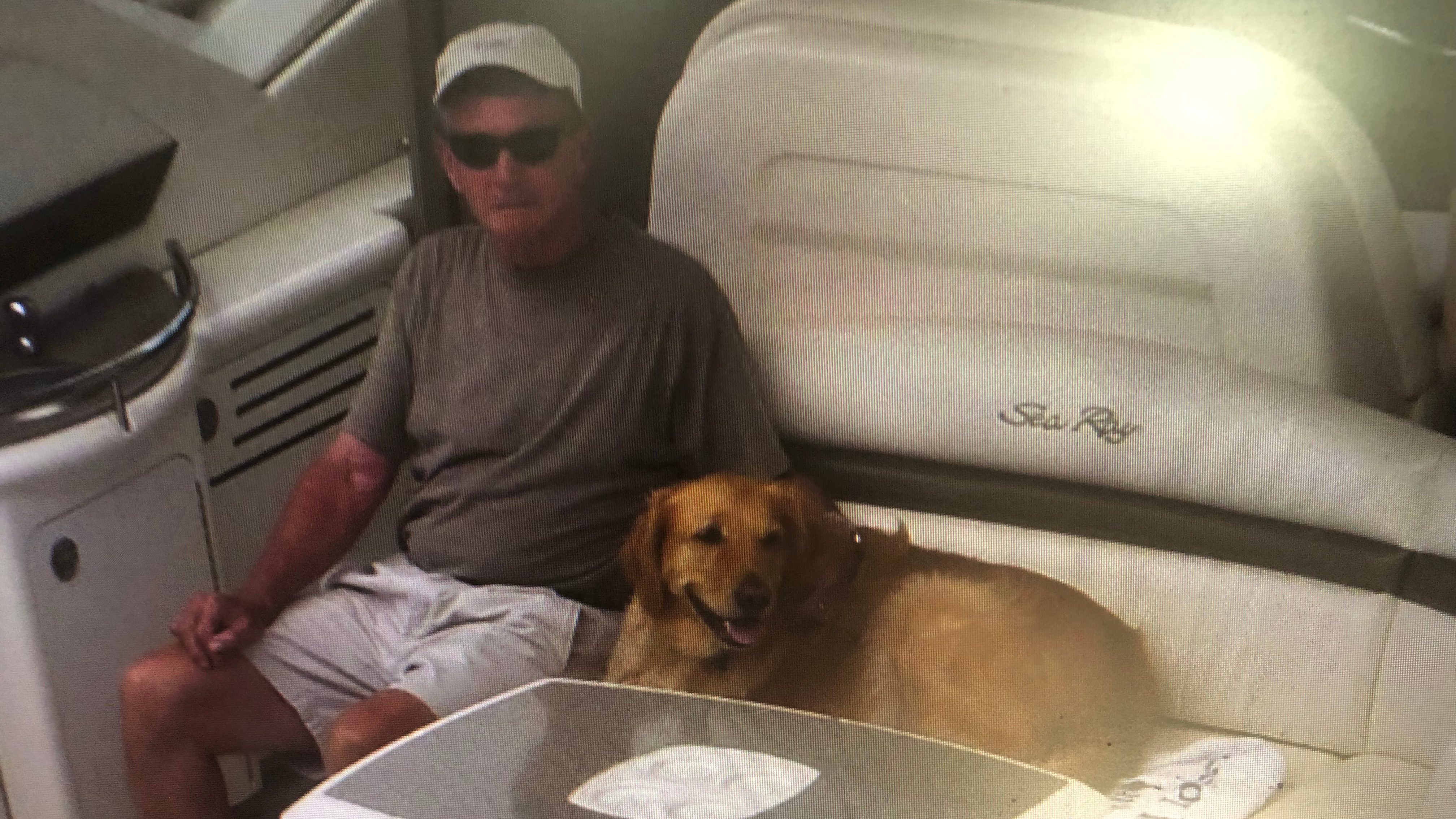 Dick Reid relaxing on a boat with his adorable dog