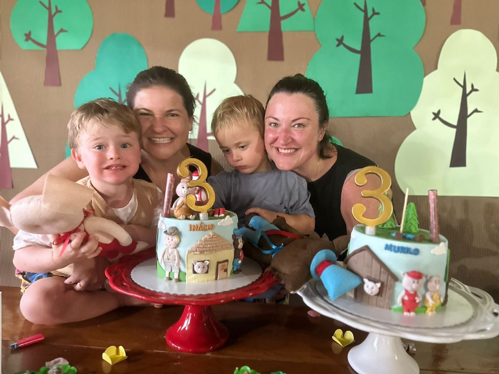 Isabela with her family celebrating a birthday with two cakes