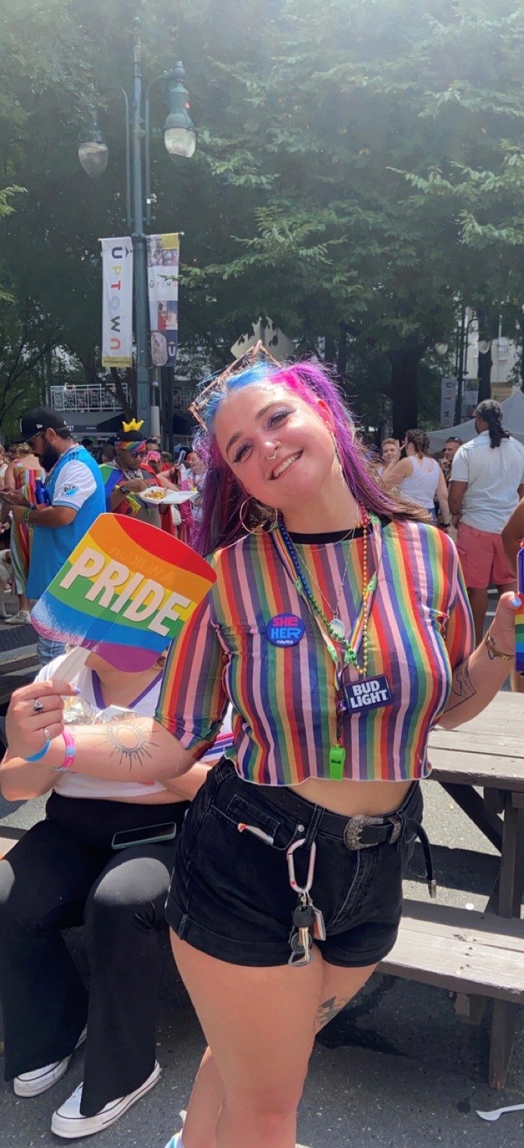 Stefany Harden smiling and holding up a Pride sign
