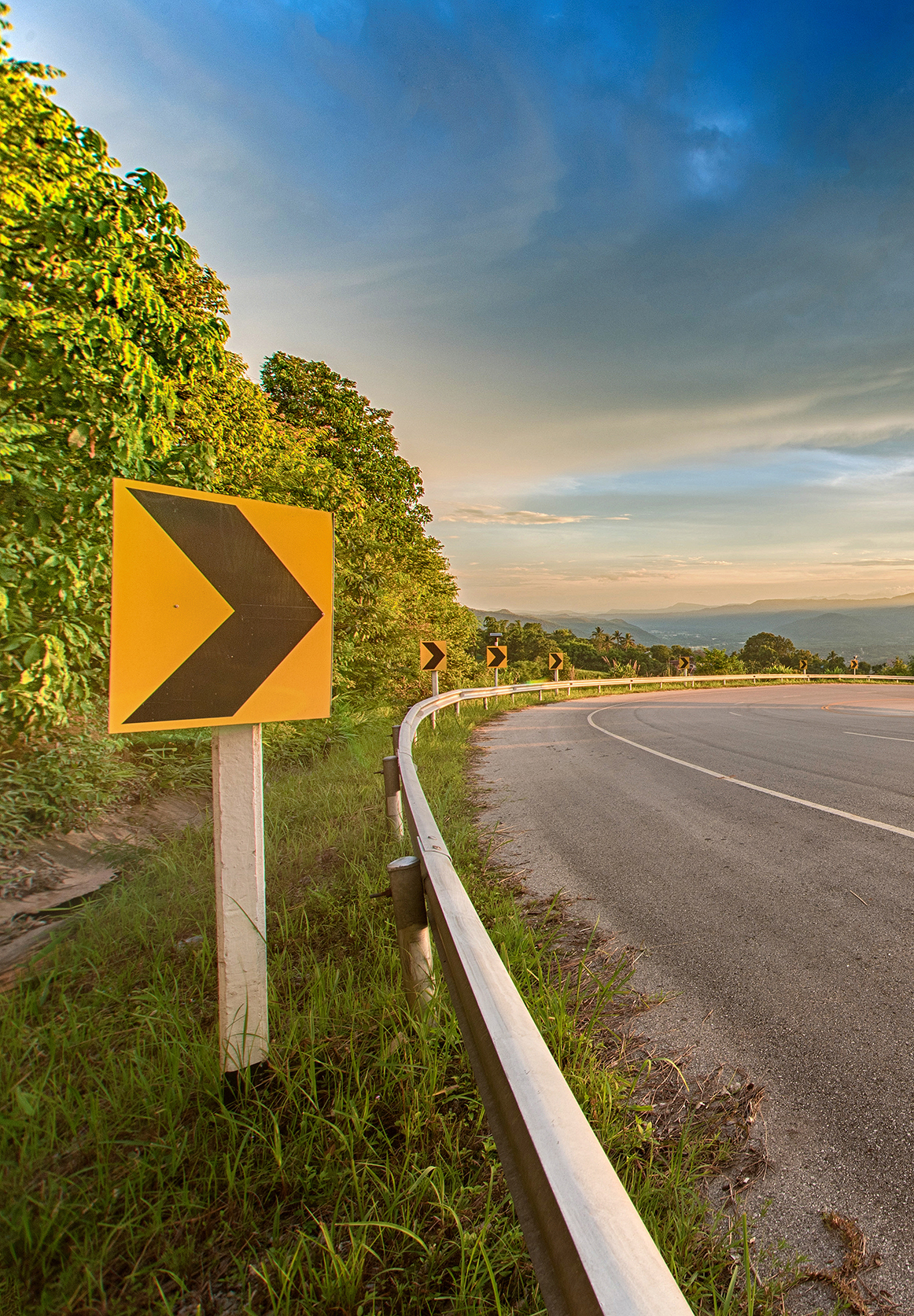 curve on the road sunset with sign symbol