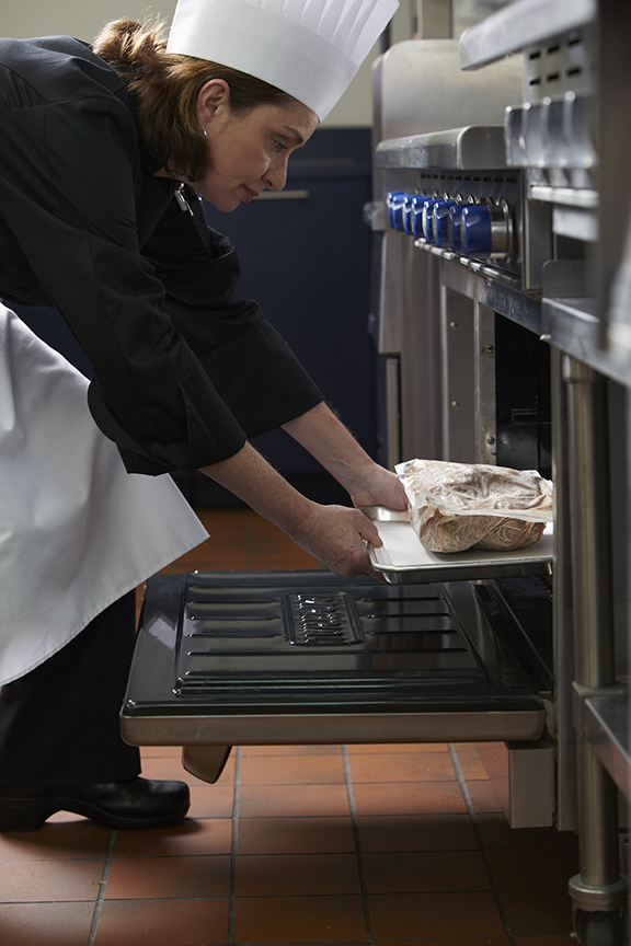 chef placing oven ease into oven