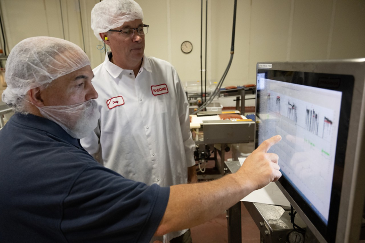 kagome plant with workers reviewing information on equipment screen