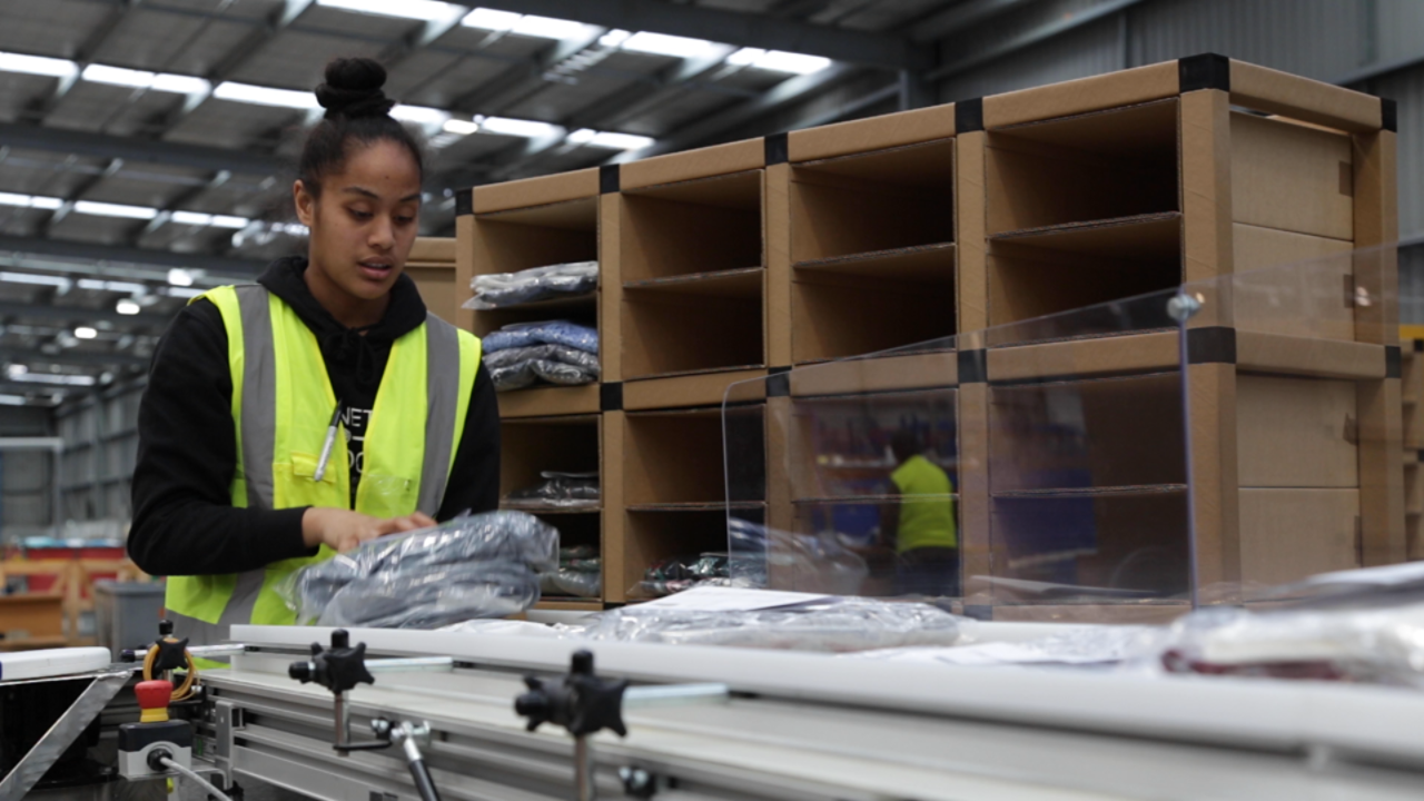 EziBuy employee working with Autobag FloWrap(R) automated mailer system